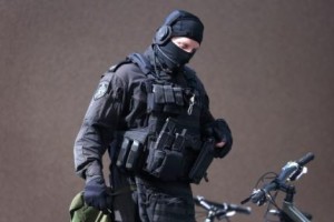 A heavily armed police officer walks near Lindt cafe, where hostages are being held,in Martin Place in central Sydney